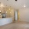 a kitchen with white cabinets and living room with wood flooring