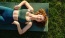a woman lying on a yoga mat outside