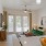 a kitchen with a bowl of oranges and view of a living room with a green couch