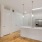 a kitchen with white cabinets and wood floors