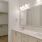 a bathroom with white cabinets sinks and large mirror